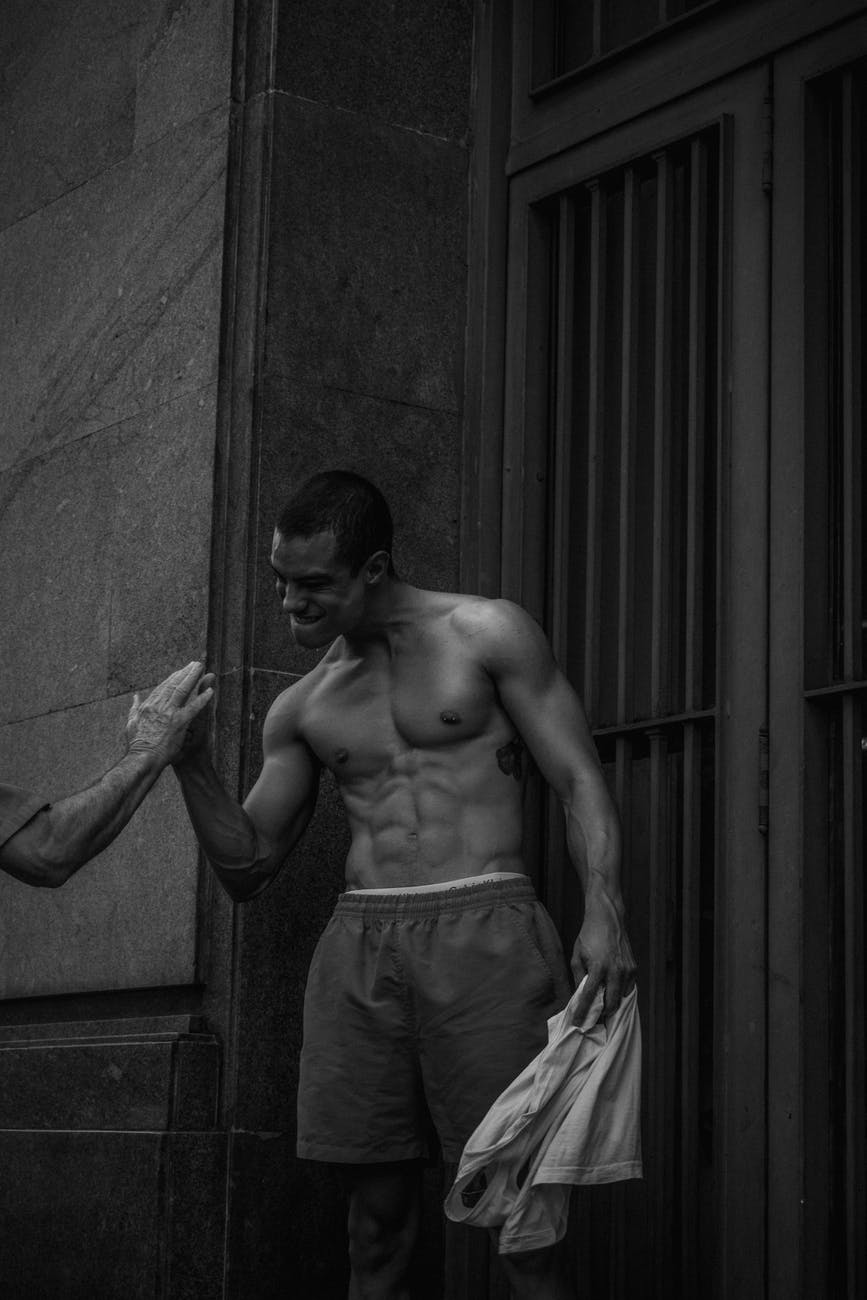 man in shorts standing near gate and holding another person s hand