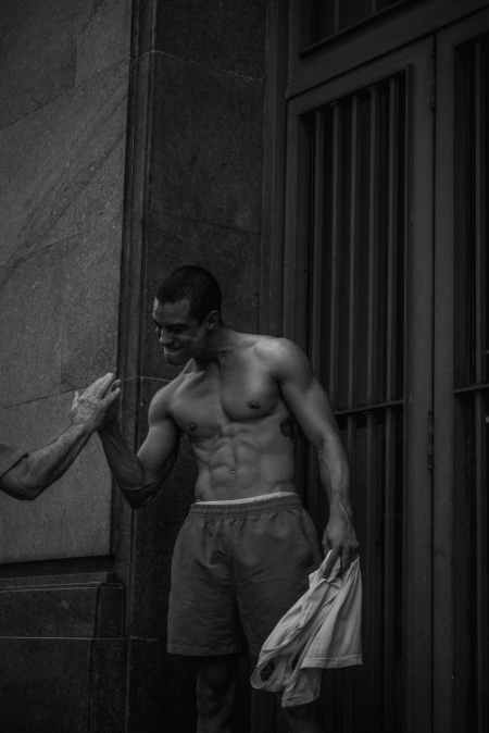man in shorts standing near gate and holding another person s hand